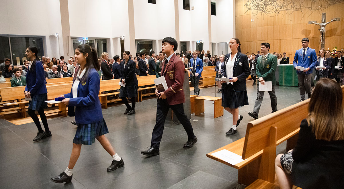 Students walking down isle to recieve award